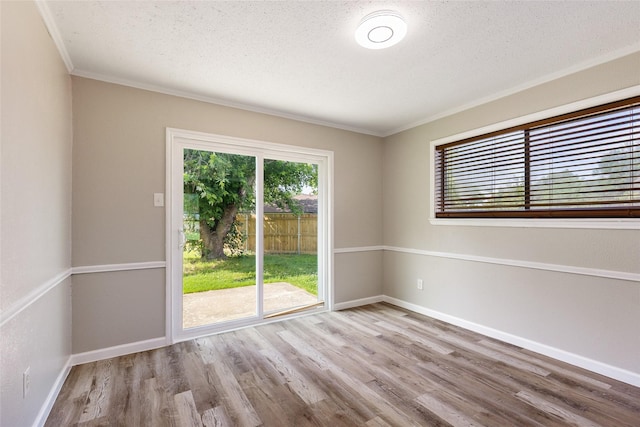 2820 Bois D Arc St, Commerce, TX 75428 - unfurnished room with wood finished floors, ornamental molding, baseboards, and a textured ceiling