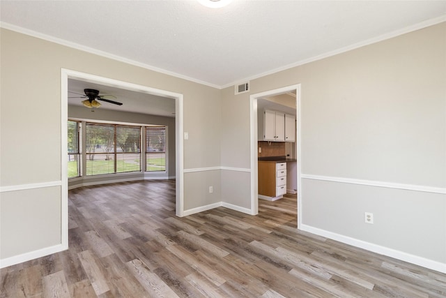 2820 Bois D Arc St, Commerce, TX 75428 - unfurnished room featuring wood finished floors, ornamental molding, baseboards, and a ceiling fan