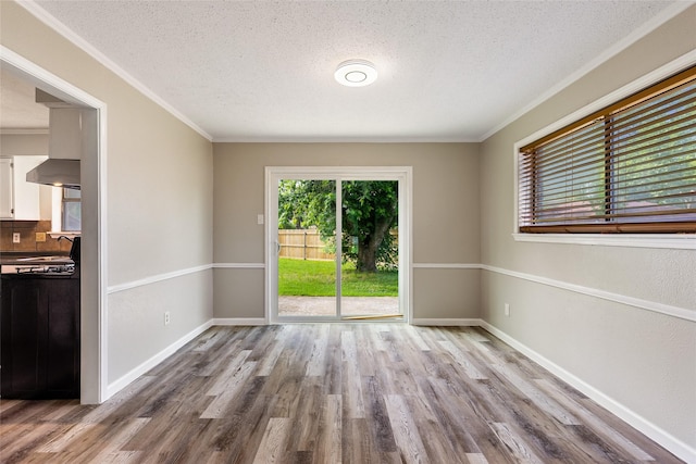 2820 Bois D Arc St, Commerce, TX 75428 - unfurnished room featuring a textured ceiling, wood finished floors, ornamental molding, a sink, and baseboards