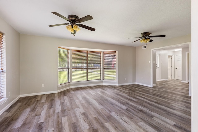 2820 Bois D Arc St, Commerce, TX 75428 - unfurnished room with ceiling fan, wood finished floors, and baseboards