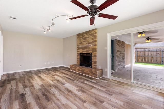 2820 Bois D Arc St, Commerce, TX 75428 - unfurnished living room with a ceiling fan, wood finished floors, and a fireplace