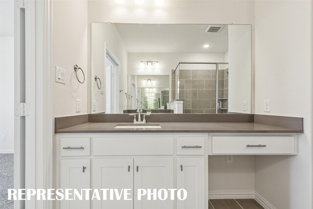 bathroom with vanity, a shower stall, visible vents, and baseboards