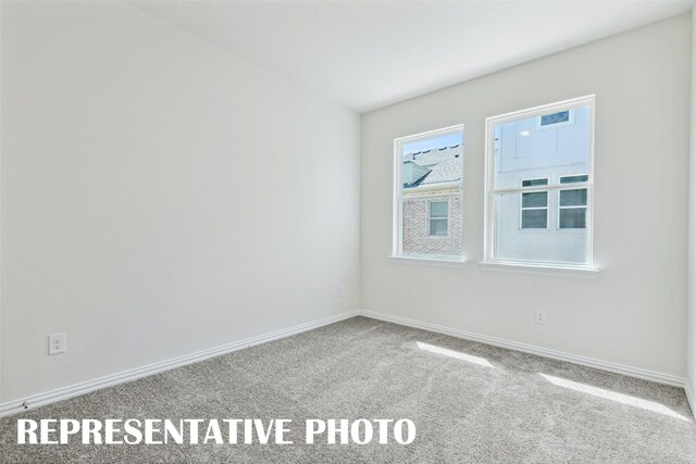 carpeted empty room with baseboards