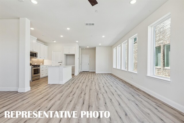 unfurnished living room featuring visible vents, recessed lighting, and light wood-style flooring