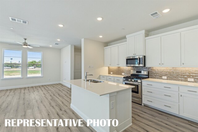 kitchen with a sink, visible vents, stainless steel appliances, and tasteful backsplash