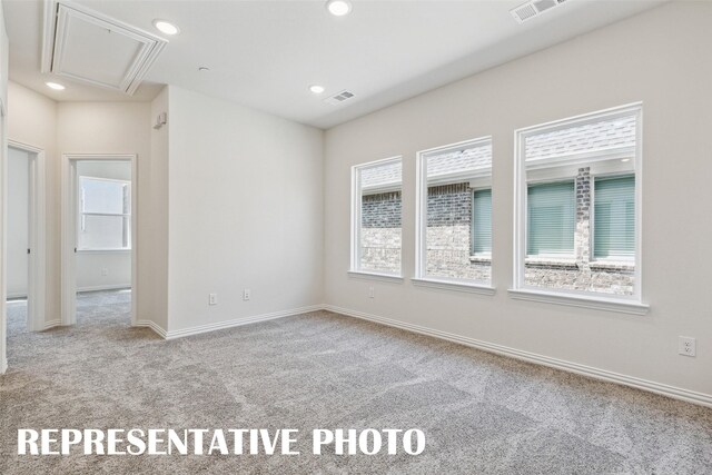 carpeted spare room featuring attic access, visible vents, recessed lighting, and baseboards