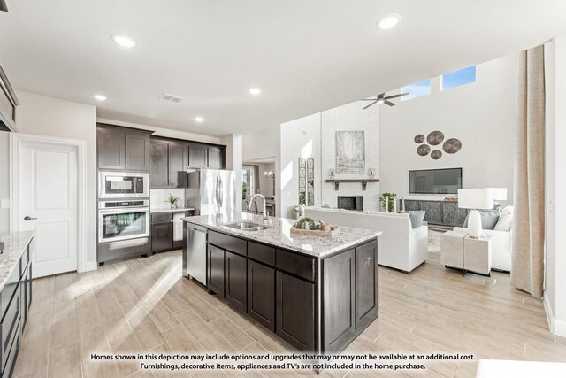 kitchen featuring a sink, visible vents, stainless steel appliances, dark brown cabinetry, and a ceiling fan