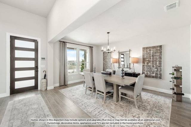 dining area featuring a chandelier, visible vents, wood finished floors, and baseboards