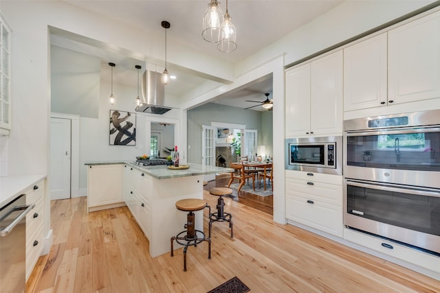 123 S Rosemont Ave, Dallas, TX 75208 - kitchen with stainless steel appliances, light wood-style floors, white cabinetry, a breakfast bar area, and ceiling fan
