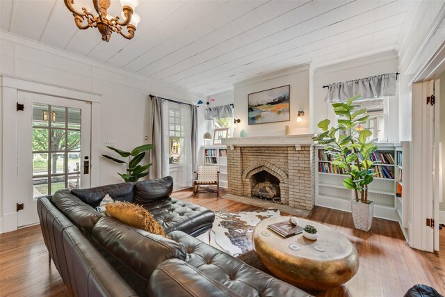 123 S Rosemont Ave, Dallas, TX 75208 - living area with ornamental molding, a chandelier, wood finished floors, and a brick fireplace