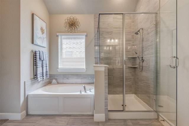 bathroom featuring a shower stall, a bath, and baseboards