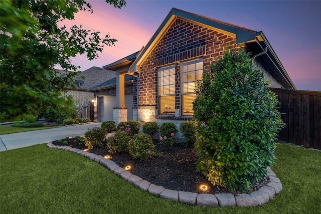 view of front of house featuring a garage, fence, a front yard, and stone siding