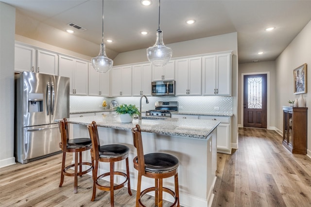 kitchen featuring decorative backsplash, light wood-style flooring, white cabinets, visible vents, and stainless steel appliances