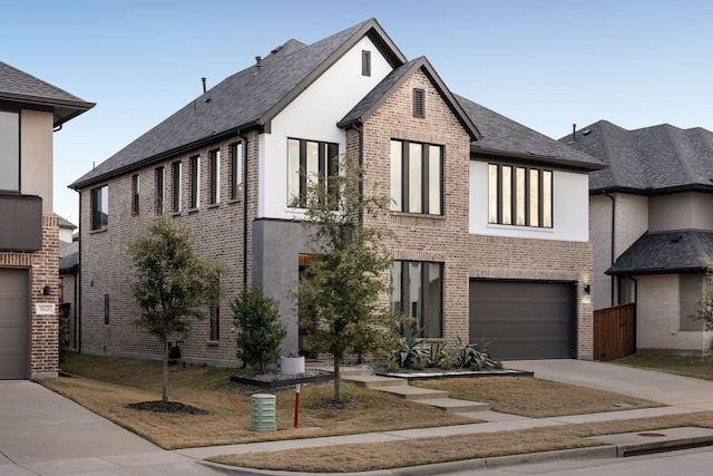 view of front of property with driveway, a garage, stucco siding, and brick siding
