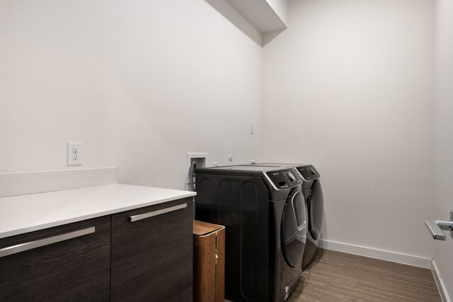 laundry room featuring wood finished floors, baseboards, laundry area, and washing machine and dryer