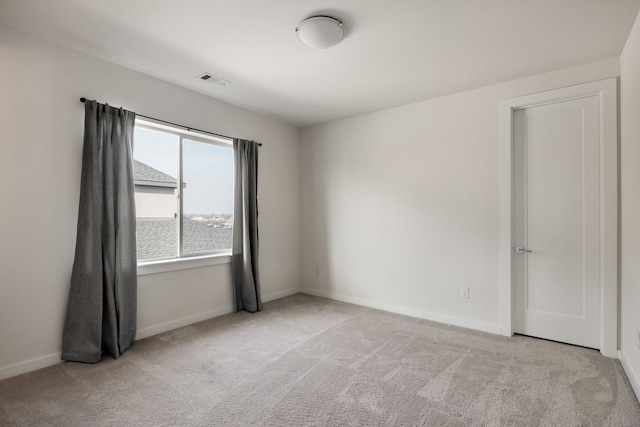 spare room with visible vents, carpet flooring, and baseboards