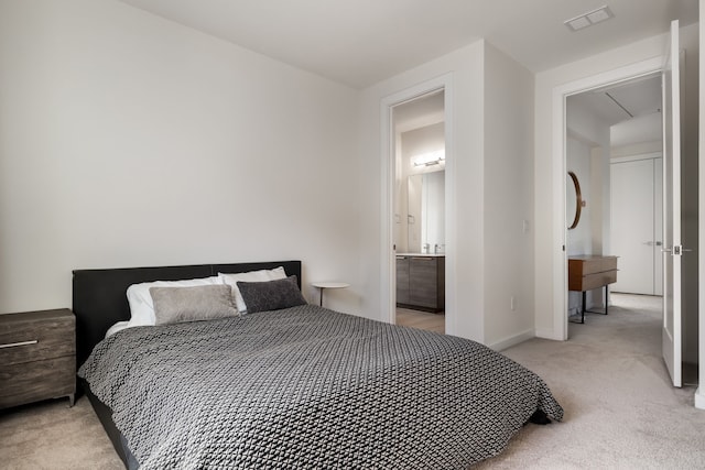 bedroom featuring baseboards, visible vents, light carpet, and ensuite bathroom