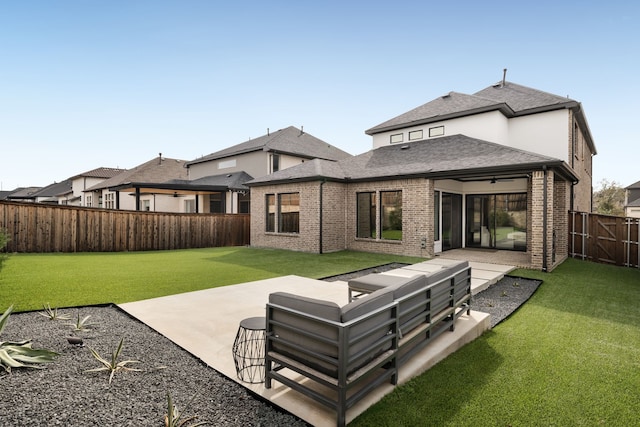 rear view of house with a fenced backyard, brick siding, roof with shingles, a patio area, and a ceiling fan