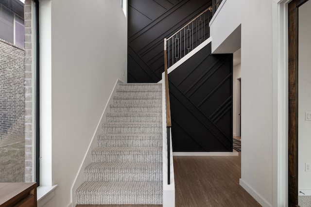 stairs with wood finished floors and baseboards