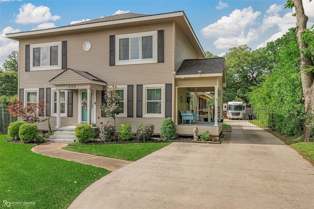 colonial inspired home featuring fence, covered porch, a front yard, a gate, and concrete driveway