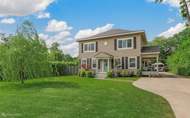 rear view of house featuring fence, a yard, and driveway