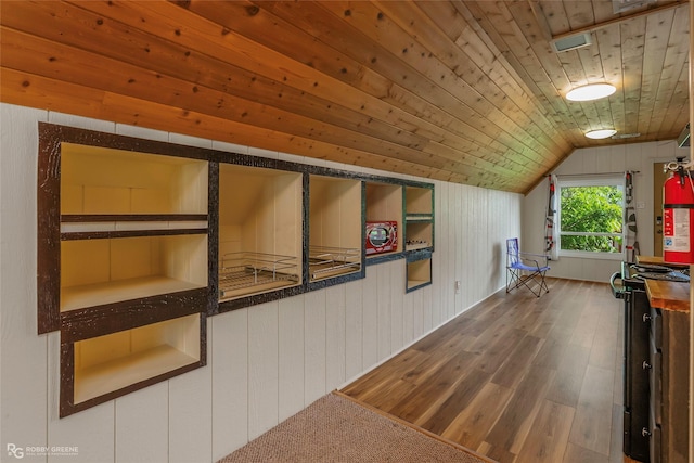 bonus room featuring wood ceiling, wood walls, wood finished floors, and lofted ceiling