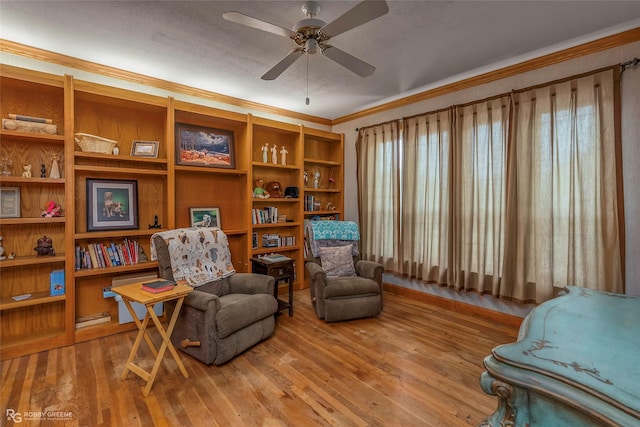 sitting room featuring crown molding, ceiling fan, hardwood / wood-style flooring, and a healthy amount of sunlight