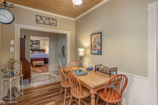 dining space featuring ornamental molding, wainscoting, and wood finished floors