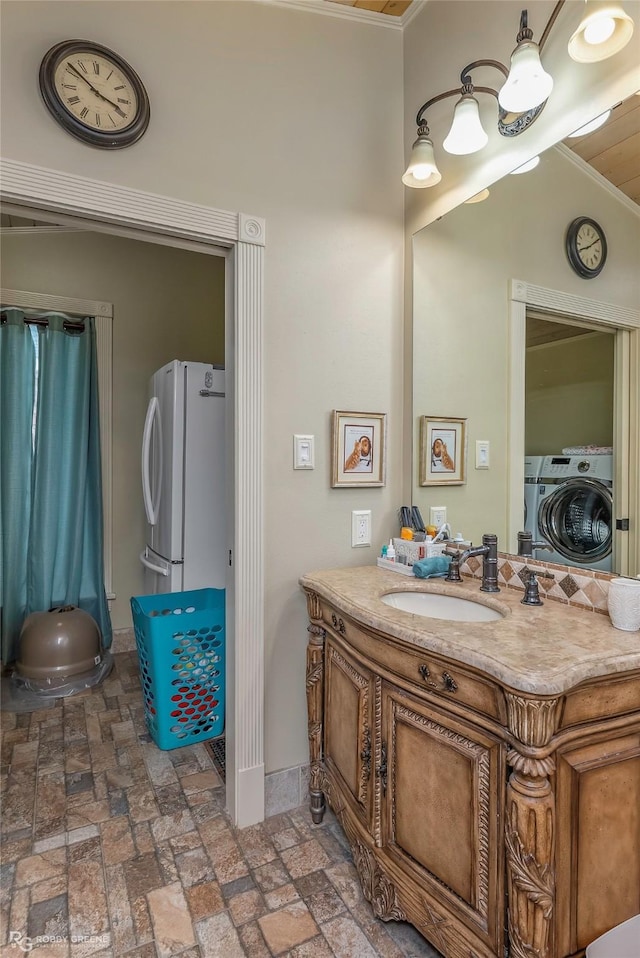 bathroom with washer and dryer, brick floor, vanity, baseboards, and ornamental molding