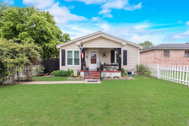 bungalow featuring a porch, a front lawn, and fence private yard