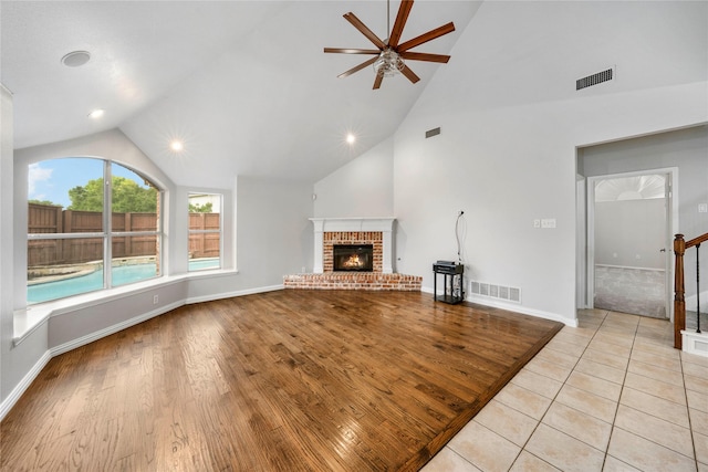 unfurnished living room with ceiling fan, visible vents, baseboards, and a fireplace