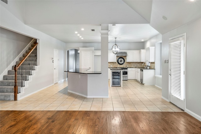 kitchen with white cabinetry, light tile patterned flooring, dark countertops, and stainless steel appliances