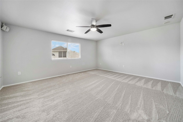 carpeted empty room with visible vents, a ceiling fan, and baseboards