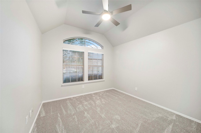 spare room featuring carpet flooring, a ceiling fan, baseboards, and lofted ceiling