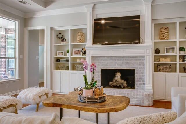 living room featuring visible vents, ornamental molding, wood finished floors, and plenty of natural light