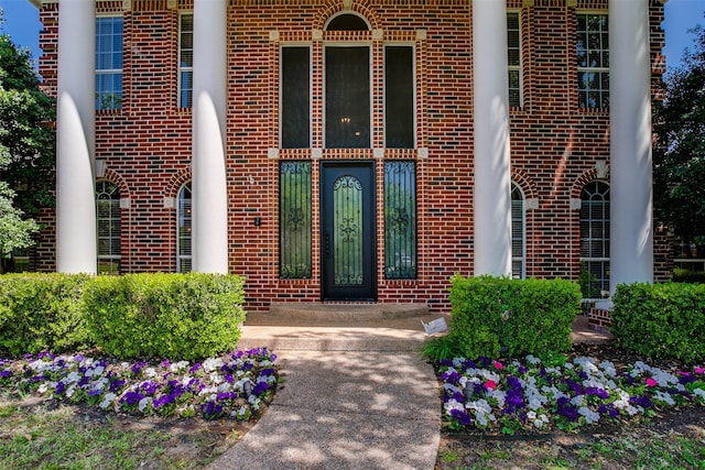 entrance to property featuring brick siding