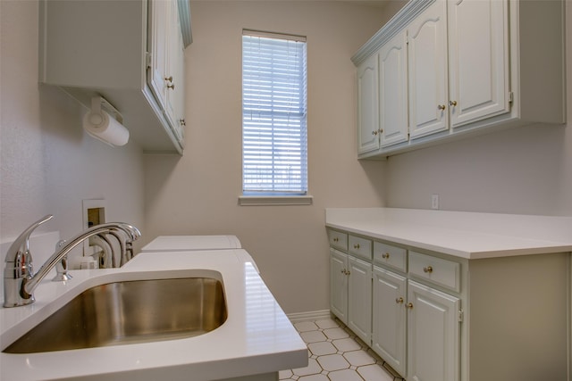 laundry area featuring a sink, a wealth of natural light, cabinet space, and washing machine and clothes dryer