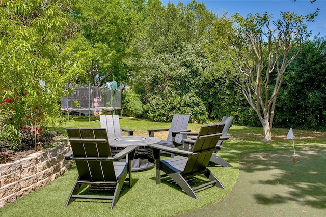 view of yard with a trampoline and an outdoor fire pit