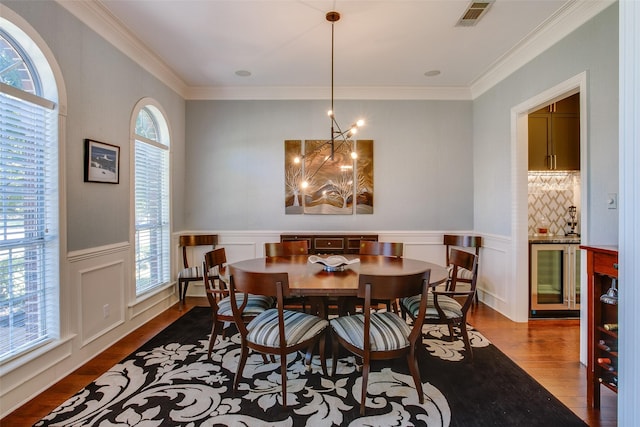 dining room featuring an inviting chandelier, dark wood-style flooring, beverage cooler, and visible vents