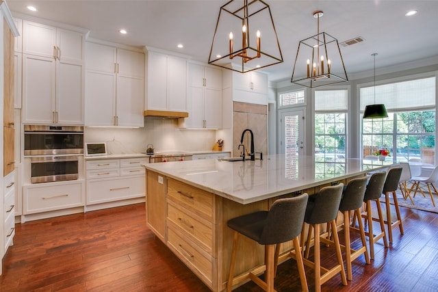 kitchen with visible vents, a sink, built in refrigerator, and dark wood-type flooring