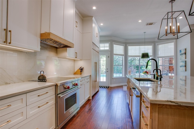 kitchen with decorative backsplash, light stone countertops, a sink, dark wood-style floors, and stainless steel appliances