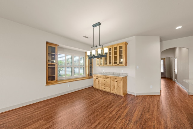 interior space featuring recessed lighting, arched walkways, wood finished floors, baseboards, and visible vents