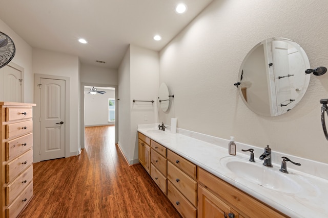full bathroom featuring double vanity, wood finished floors, visible vents, and a sink