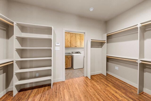 walk in closet with light wood-style flooring and washer / clothes dryer