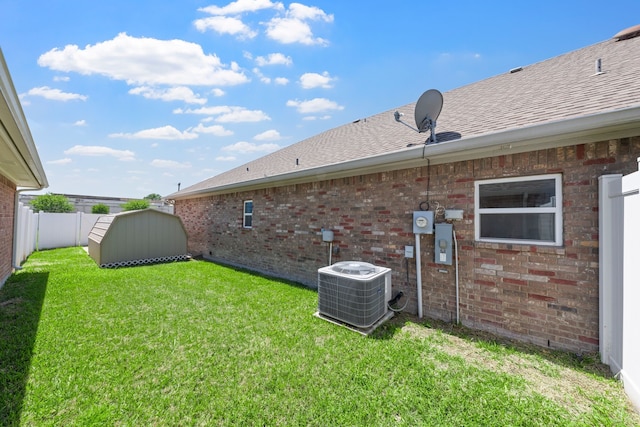 view of yard with a storage shed, cooling unit, an outbuilding, and a fenced backyard
