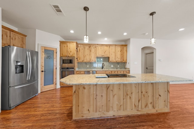 kitchen featuring wood finished floors, arched walkways, light brown cabinetry, stainless steel appliances, and visible vents