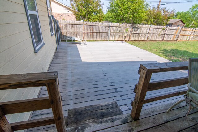 deck featuring a lawn and a fenced backyard