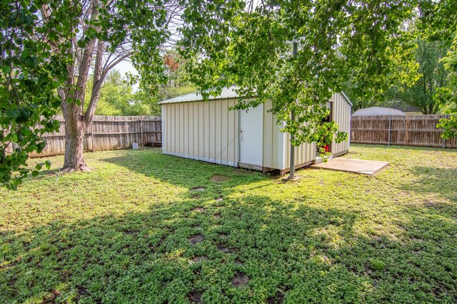 view of yard featuring an outbuilding, a storage unit, and a fenced backyard