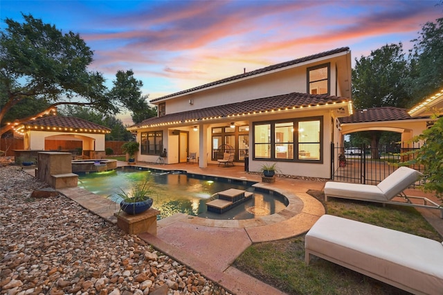 5314 Meritage Ln, Grapevine, TX 76051 - back of house at dusk with stucco siding, a fenced backyard, a patio area, a tile roof, and a ceiling fan