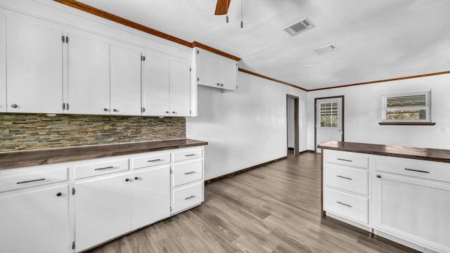 760 College Farm, Stephenville, TX 76401 - kitchen featuring decorative backsplash, light wood-type flooring, crown molding, visible vents, and butcher block counters